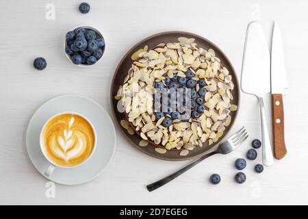 Cheesecake au chocolat maison avec myrtilles et tranches d'amande sur table en bois blanc. Vue de dessus. Banque D'Images