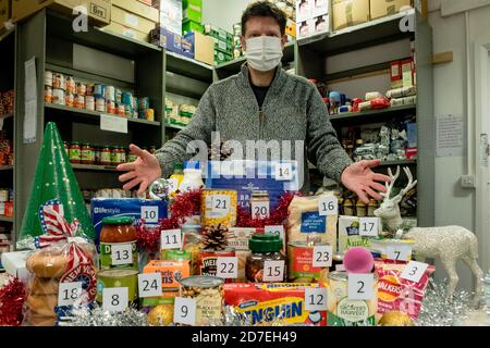 Un volontaire en masque Covid-19 avec un avènement inversé Calendrier de collecte de dons alimentaires à une église Trussell Trust banque alimentaire Banque D'Images