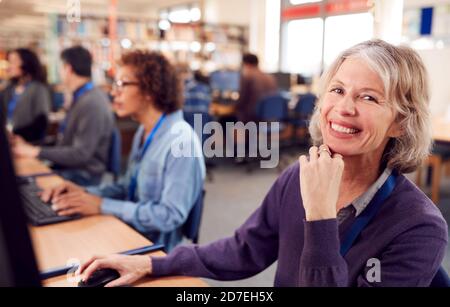 Portrait d'une femme adulte en classe travaillant à Ordinateurs dans la bibliothèque de l'université Banque D'Images
