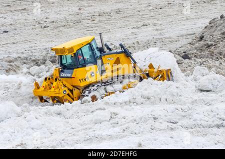 Les pelles de bulldozer 750J de Yellow Deere tirent des tas de neige. Russie, Saint-Pétersbourg. 19 février 2019 Banque D'Images