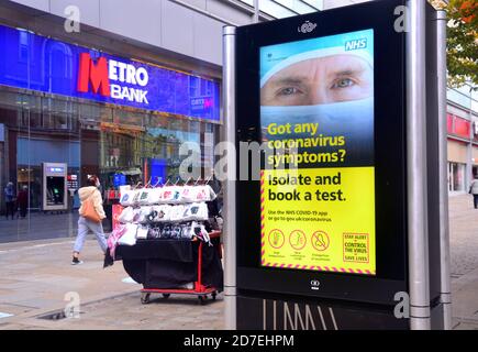 Covid 19 ou coronavirus signalisation et publicité à Manchester, Grand Manchester, Angleterre, Royaume-Uni. Un panneau NHS illuminé qui incite les gens à faire un test s'ils ont des symptômes. Banque D'Images