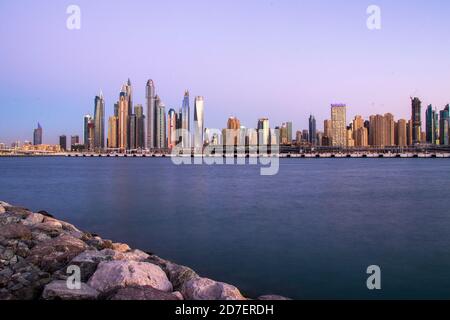 Vue sur UNE marina de Dubaï après le coucher du soleil. Prise de vue réalisée à partir de Palm Jumeirah, île artificielle. Dubaï, Émirats arabes Unis. À l'extérieur. Banque D'Images