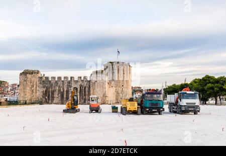 Construction de camions et de tracteurs sur un terrain blanc près de la forteresse Kamerlengo du XVe siècle à Trogir, Croatie Banque D'Images