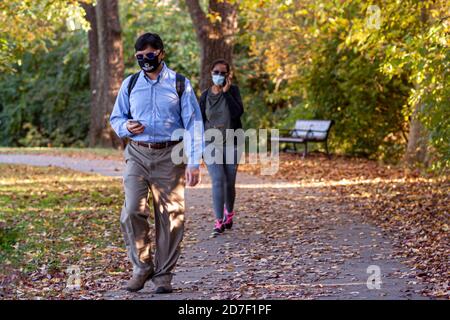 Frederick, MD, USA 10/14/2020: On voit un jeune homme professionnel indien et une femme afro-américaine marcher dans Baker Park avec des masques faciaux en raison de la COV Banque D'Images