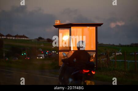 Brighton UK 22 octobre 2020 - le soleil couchant se reflète dans un arrêt de bus par Brighton Racecourse à l'est de la ville, car le temps instable devrait se répandre à travers la Grande-Bretagne au cours des prochains jours : Credit Simon Dack / Alay Live News Banque D'Images