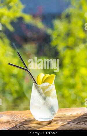 Cocktail d'été avec pomme verte et glace sur la table blanche près de la fenêtre en été ensoleillé. Image à mise au point sélective avec espace de copie Banque D'Images