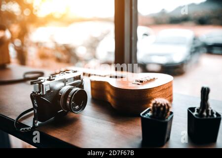 Caméra de cinéma vintage, ukulele, et cactus, intérieur de café Banque D'Images