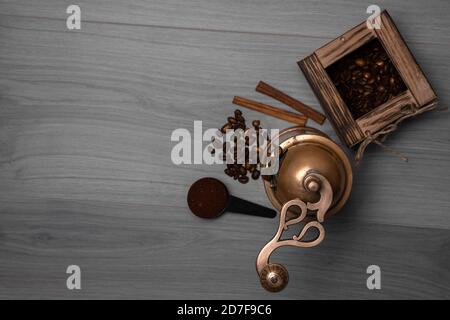 Grains de café dans une boîte en bois, bâtonnets de cannelle, café moulu dans une cuillère, moulin à café vintage Banque D'Images