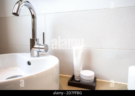 collection de différentes bouteilles blanches et blanches d'hygiène de beauté dans la salle de bains moderne près du lavabo blanc, Banque D'Images