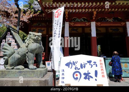 La statue de la bête de garde devant le principal salle du Temple Senso-Ji avec une prière à côté.Temple Senso-Ji.Asakusa.Tokyo.Japon Banque D'Images