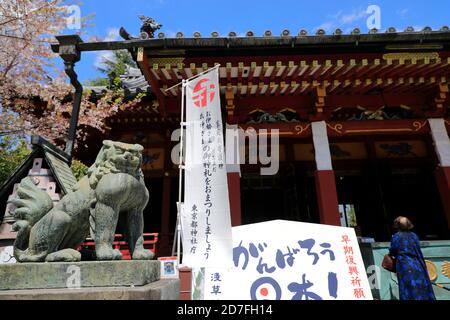 La statue de la bête de garde devant le principal salle du Temple Senso-Ji avec une prière à côté.Temple Senso-Ji.Asakusa.Tokyo.Japon Banque D'Images