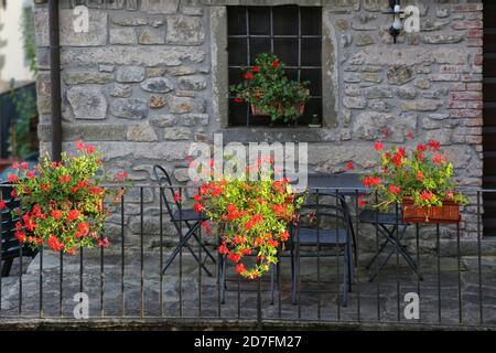 Lucca, Italie. Façade traditionnelle et ancienne en pierre d'une maison en haute Toscane avec de belles fleurs. Banque D'Images