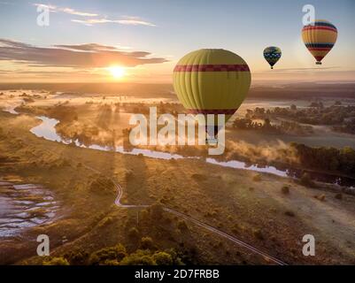 Montgolfière au-dessus de la rivière au coucher du soleil. Voyage, liberté, aventure, exploration, concept extrême. Banque D'Images