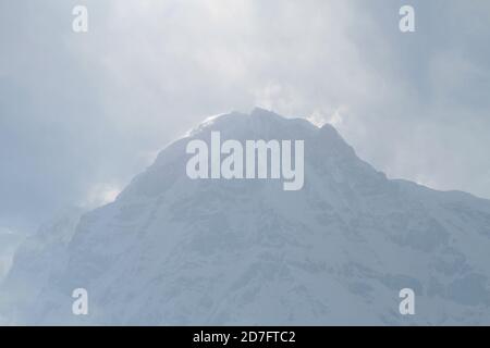 Photo majestueuse d'un massif rocheux enneigé de l'Annapurna avec des pics dans les nuages, au Népal, dans l'Himalaya Banque D'Images