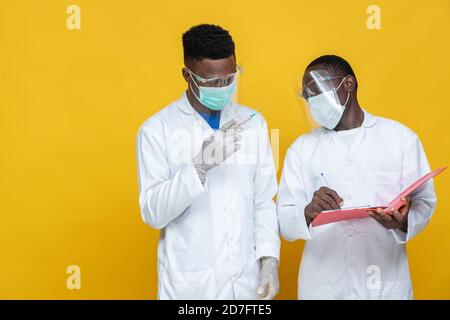 portrait de deux médecins noirs en blouses de laboratoire portant un examen et des tests Banque D'Images