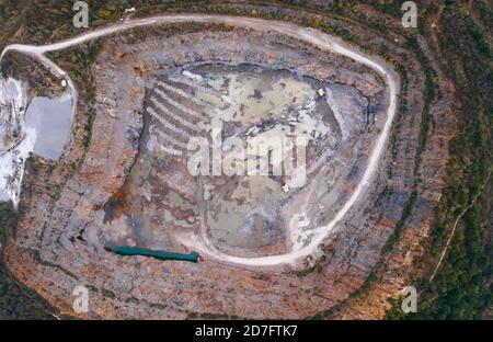 Vue aérienne de la carrière de drone en Europe au coucher du soleil d'été, carrière de pierre concassée, belle nature ronde, quelques excavateurs, excavateurs à l'intérieur Banque D'Images