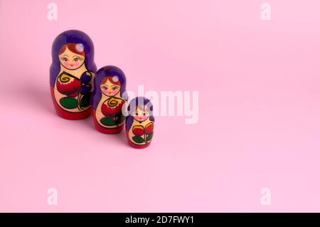 détail de matryoshka poupées de différentes couleurs sur un lisse fond rose Banque D'Images