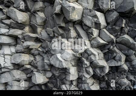 Toile de fond des formations rocheuses volcaniques de basalte dans la plage de Reinisfjara à proximité Vik dans le nord de l'Islande Banque D'Images