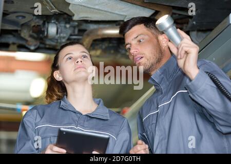 L'homme et la femme la mécanique automobile dans un garage automobile Banque D'Images
