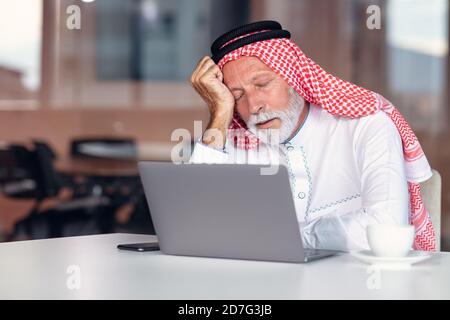 L'homme d'affaires arabe est ennuyeux dans les bureaux modernes. Fatigué. Banque D'Images