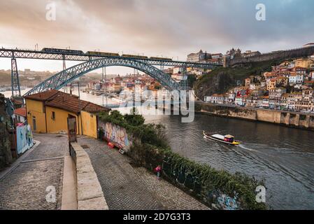 Porto, Portugal - 20 novembre 2019 : pont Luis I, métro le traversant, bateau à passagers dans le fleuve Douro, séparant Porto et Vila Nova de Gaia. Banque D'Images