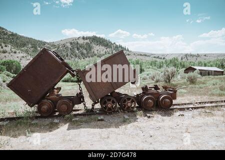 De vieux chariots de minerai rouillé sur les pistes dans le Ville fantôme de Bannack dans le Montana Banque D'Images