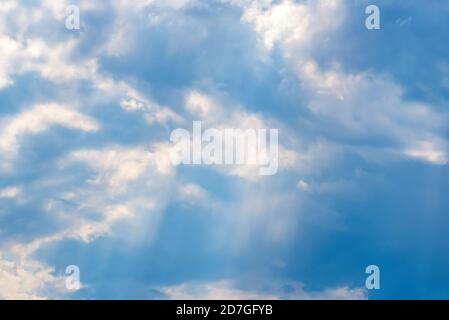 Les rayons du soleil tombent des nuages sur le ciel bleu Banque D'Images