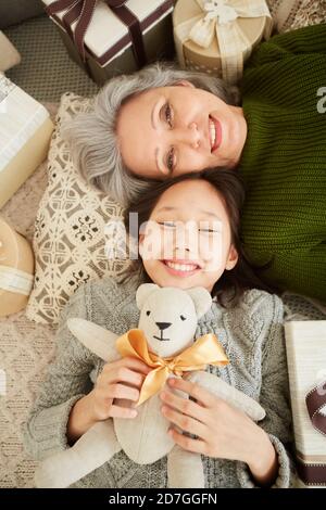 Vue en grand angle de la petite-fille et de la grand-mère le sol ensemble et souriant à la caméra Banque D'Images