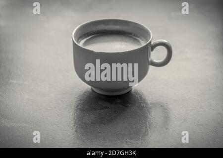 Photo en niveaux de gris d'une tasse à café en grand angle Banque D'Images