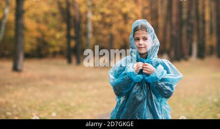 Portrait d'une jeune fille qui marche dans le parc sous la pluie. Banque D'Images