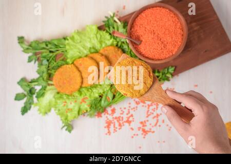 hamburgers de lentilles vegan dans une assiette en bois avec salade verte sur fond clair. aliments sains végétariens. lentilles dans une assiette en bois. vue de la t Banque D'Images