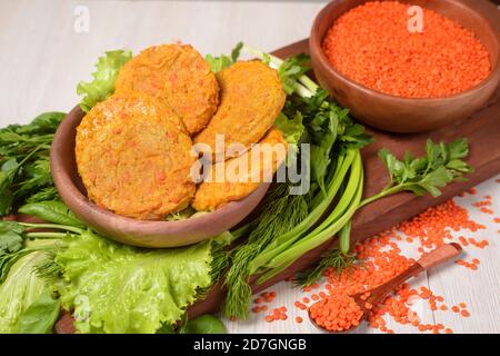 boulettes de viande végétariennes à base de lentilles et de carottes dans une assiette en bois avec légumes et légumes verts. aliments sains. lentilles rouges dans une assiette en bois Banque D'Images