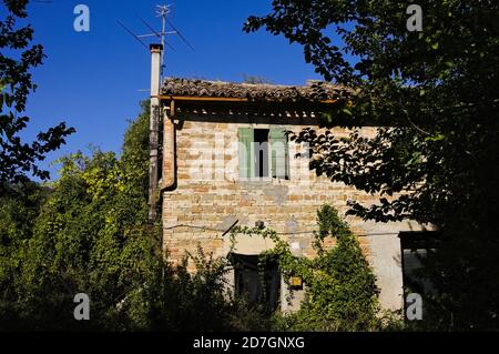 Un cottage abandonné dans la campagne italienne avec une fenêtre ouverte et une cheminée (Pesaro, Italie, Europe) Banque D'Images