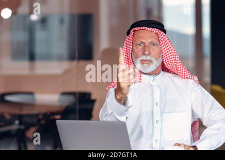 Un homme d'affaires arabe pointe un doigt d'avertissement sur la caméra. Banque D'Images