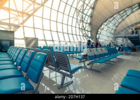 Siège flou dans le salon des départs du terminal de l'aéroport. Distance pour un siège garder la distance pour protéger le coronavirus et les passagers de distance sociale pour les s. Banque D'Images