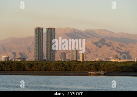 Ras al Khaimah, United Arab Emirates Corniche vue portrait sur les montagnes Hajar et les tours Julphur au coucher du soleil. Banque D'Images