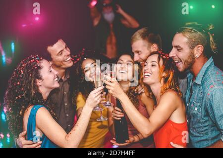 Des amis heureux célébrant les vacances de la Saint-Sylvestre dans un club de discothèque - jeunes faisant partie privée avec deejay et boire champagne Banque D'Images