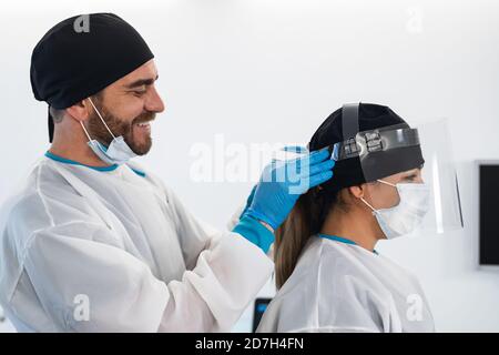 Chirurgiens souriant après une opération chirurgicale réussie - les travailleurs médicaux les vrais héros pendant l'épidémie de virus corona Banque D'Images