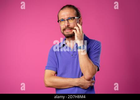 Confus barbu jeune homme pensant à quelque chose Banque D'Images