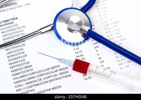 Un stéthoscope sur les résultats d'une évaluation médicale et une seringue avec du sang Banque D'Images