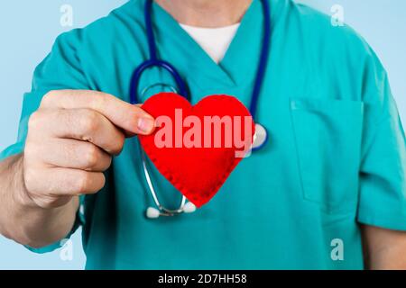 Médecin avec un stéthoscope tenant un coeur en tissu rouge en vue rapprochée Banque D'Images