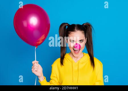 Gros plan portrait d'elle belle attrayante drôle et gai tricherie fille marron-cheveux clown tenant dans la main air ball rire isolé sur lumineux Banque D'Images