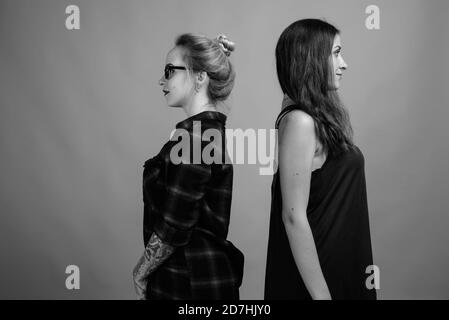 Deux jeunes belles amies sur fond gris Banque D'Images