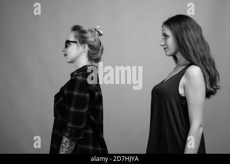 Deux jeunes belles amies sur fond gris Banque D'Images