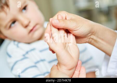 Enfant subissant une ostéopathie ou une physiothérapie pour des douleurs au poignet Banque D'Images