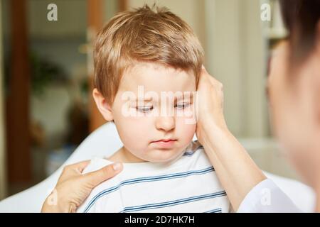 Enfant anxieux subissant la chiropratique ou la physiothérapie pour la douleur d'épaule Banque D'Images