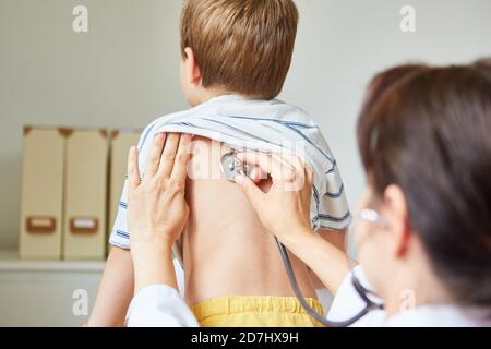 Pédiatre avec stéthoscope à l'écoute d'un poumon chez l'enfant avec bronchite et toux Banque D'Images