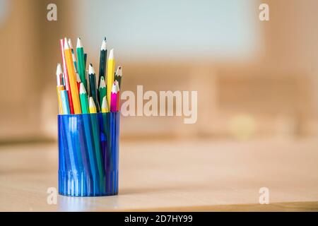 Dessin crayons de couleur en bois disposées en lumière bidon en plastique sur l'arrière-plan de l'espace de copie. Banque D'Images