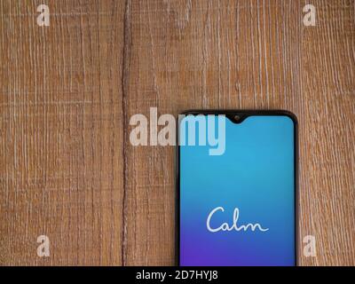 LOD, Israël - 8 juillet 2020 : écran de lancement de l'application Calm avec logo sur l'écran d'un smartphone mobile noir sur fond de bois. Vue de dessus, poser à plat avec Banque D'Images