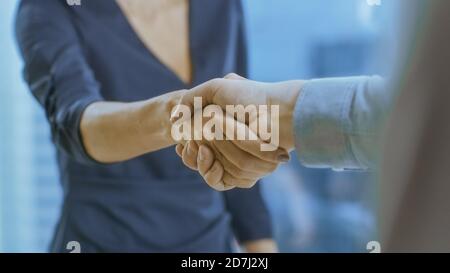 Out of Focus Businesswoman secoue la main avec un homme d'affaires. Mains dans le focus. Finalisation de la transaction et conclusion du contrat avec une poignée de main. Banque D'Images